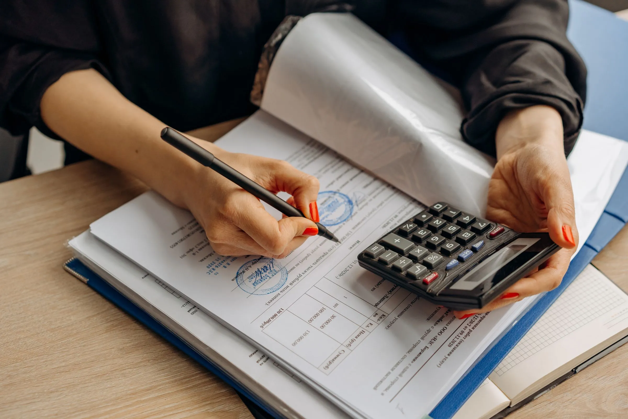 An accountant working through documents with a calculator