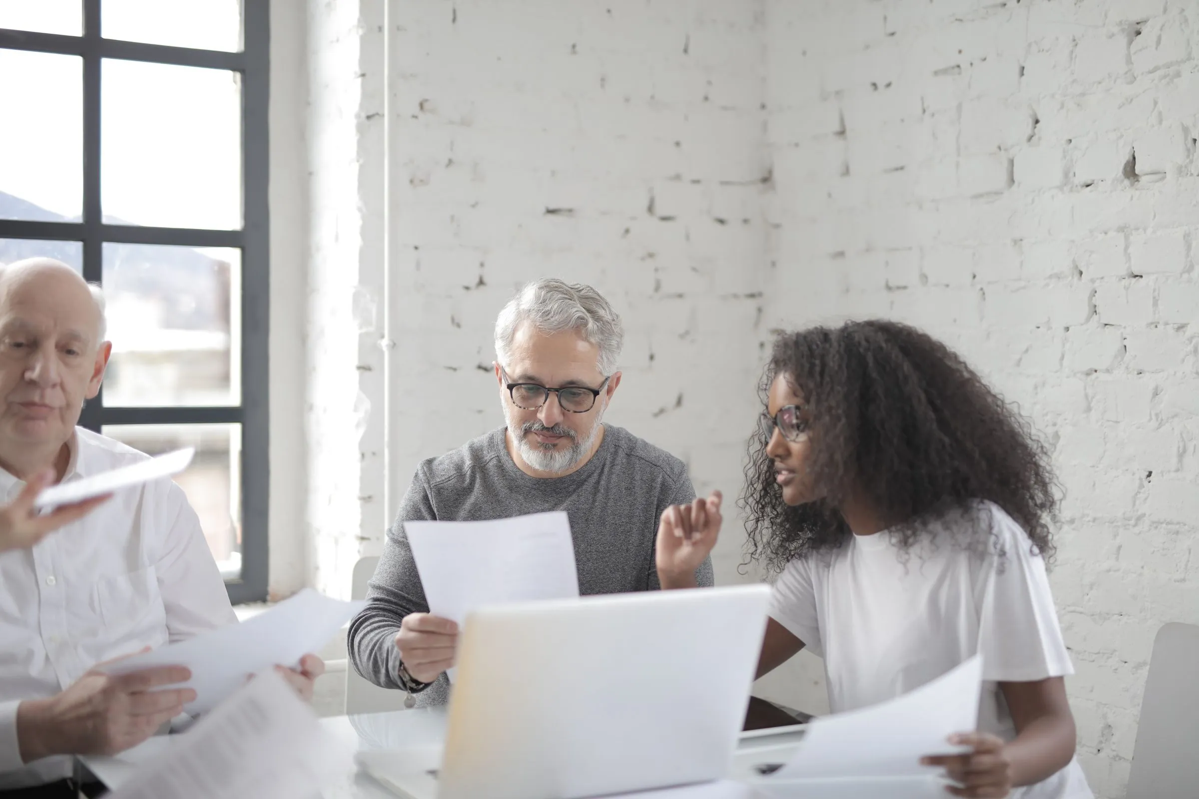 An adviser reviewing paperwork with two clients