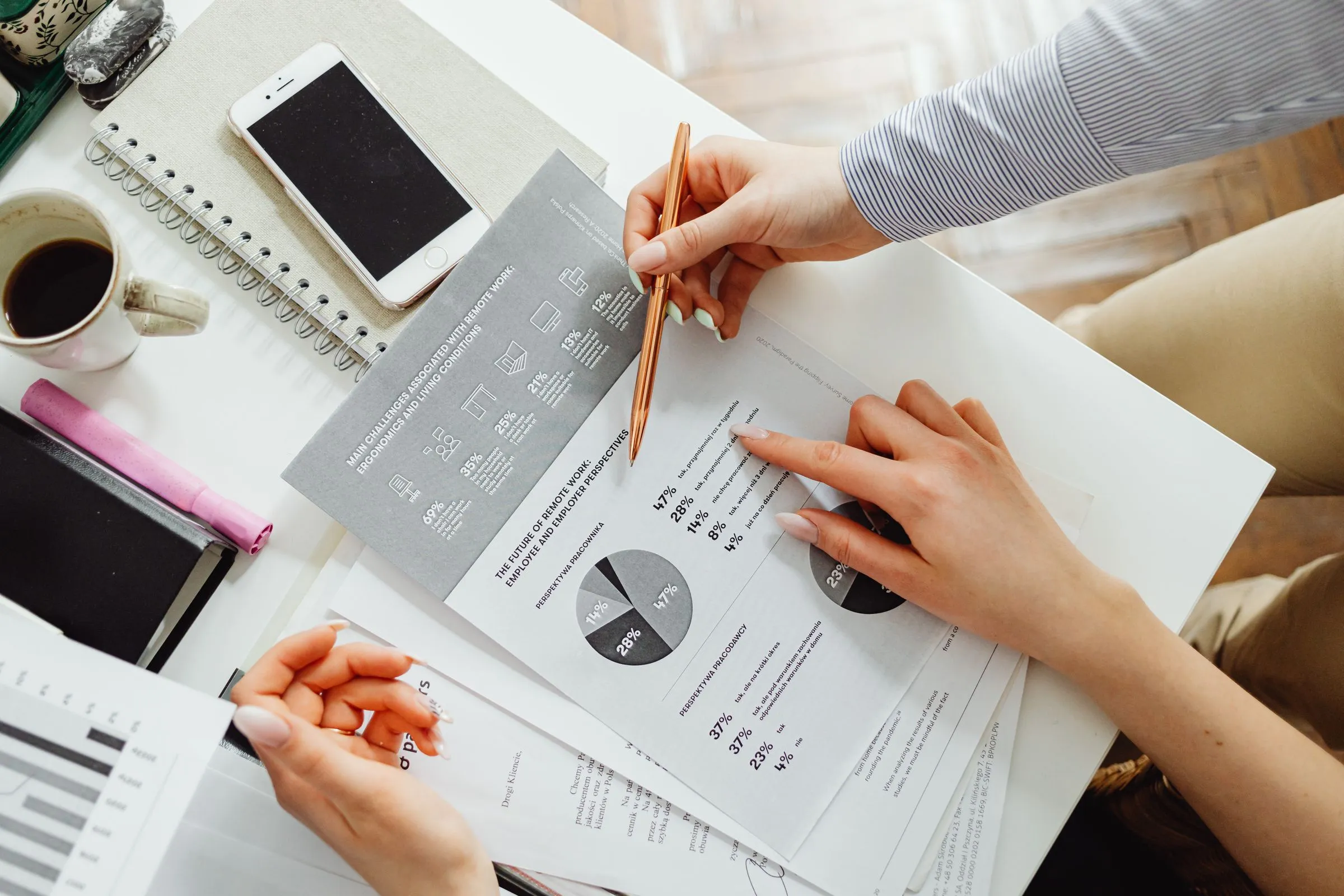 Hands reviewing printed financial reports and charts